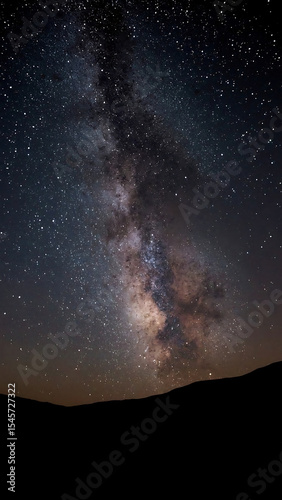 Galaxy background with Milky Way arching over majestic mountain range, perfect for astronomy, nature, space, travel designs, and backgrounds.