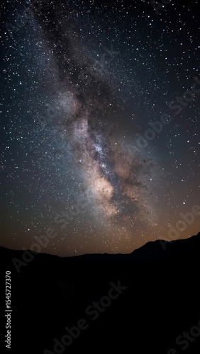 Galaxy background with Milky Way arching over majestic mountain range, perfect for astronomy, nature, space, travel designs, and backgrounds.