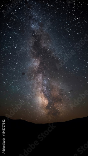 Galaxy background with Milky Way arching over majestic mountain range, perfect for astronomy, nature, space, travel designs, and backgrounds.