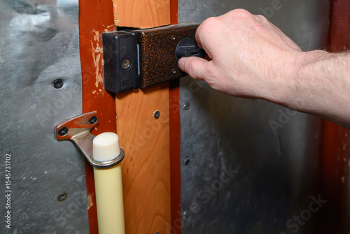 a man opens the lock on the front door of an apartment, a wooden door covered with metal