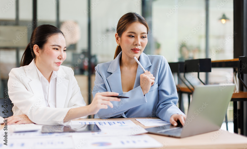 Fototapeta premium Portrait of Two casual asian business women at work.doing planning analyzing the financial report, business plan investment, finance analysis concept 