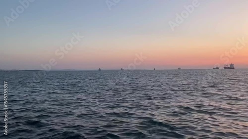 Marine Sunset: Orange Sea & Silhouetted Vessels