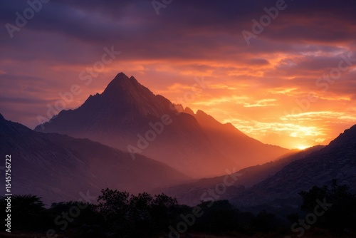 A mountain range with a sunset in the background