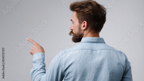 A man with a beard pointing at something