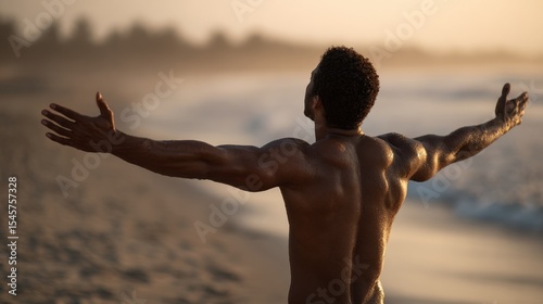 A man standing on a beach with his arms outstretched