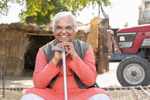 Canvas Print Happy senior man with walking cane at village.