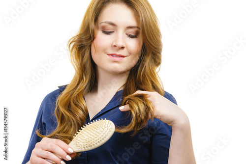 Woman brushing long healthy brown hair