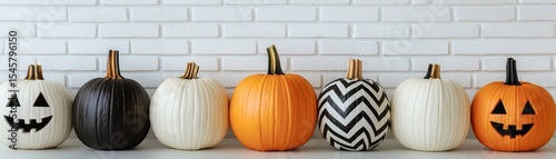 A row of pumpkins lined up, each with a unique design, perfect for autumn or Halloween. The pumpkins are set against a rustic brick wall, creating a festive feel.