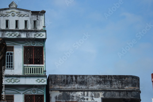 an old building with peeling paint and mold that is starting to turn black against a blue sky background