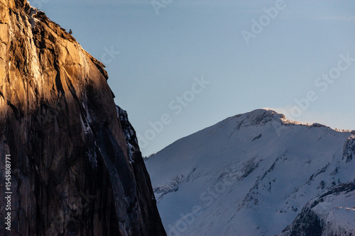 The first rays of the morning sun reflect off the rocks of the Sierra mountains in Yosemite national park, on a snow-covered new years day.