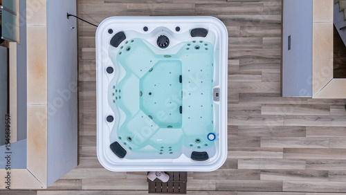 Jacuzzi on terrace with wood-style flooring