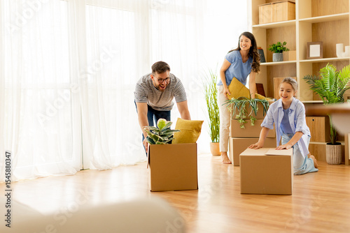 Moving boxes and cheerful friends prepare to transform their new home with plants and vibrant décor in a sunny living space
