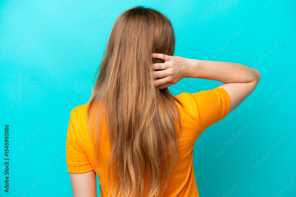 Young caucasian woman isolated on blue background in back position and thinking Young caucasian woman isolated on blue background in back position and thinking