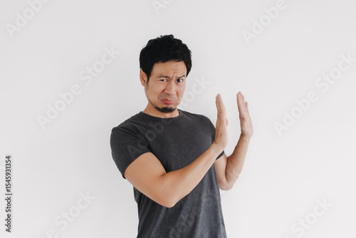 Asian man showing stop gesture with serious expression