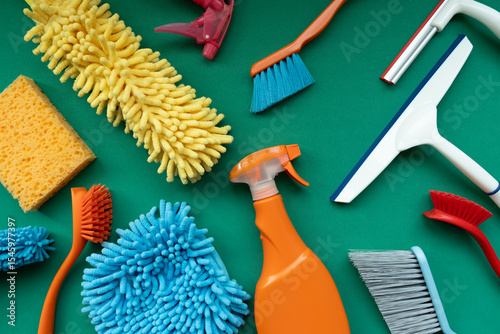 House cleaning plastic product on green table background, home service or housekeeping concept