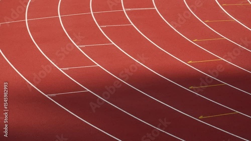 Rubberized artificial racing lane surface for track athletics, white lines and curved in the stadium.