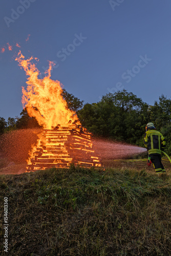 Feuerwehrmann im Einsatz beim Sonnwendfeuer im Lenninger Tal. 