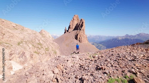 Young hiker enjoying the stunning mountain views in front of Agujas de Lavasar, 4K drone aerial footage in the Pyrenees of Aragón, remote alpine landscape in Chistau Valley, Spain, Cotiella region
