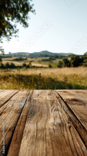 wooden surface of table in the foreground, meadow in the background, copy space.