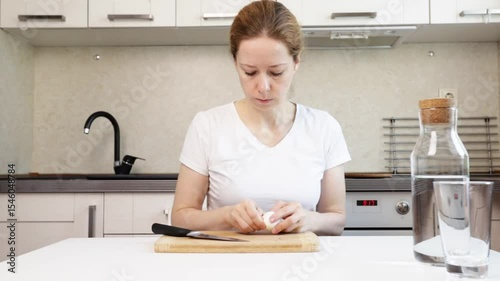 Woman peeling eggs in the kitchen, cooking fresh meals for natural nutrition, domestic lifestyle at a table.
