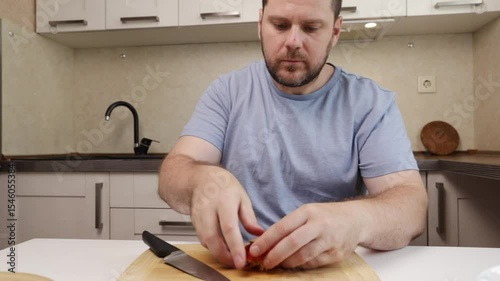 man cutting nectarine in the kitchen, middle-aged adult nutrition preparing, fruit lunch