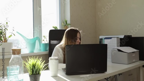 Home Office Workspace with Female Working on Laptop Near Window