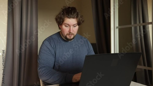 Happy man at laptop, business professional celebrating a victory in a digital workspace, enthusiasm and amazement indoors.
