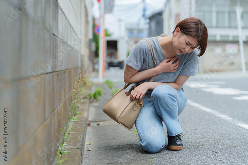 体調不良でうずくまる女性