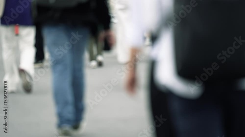 Low angle view of people walking on crowded street. Slow motion.