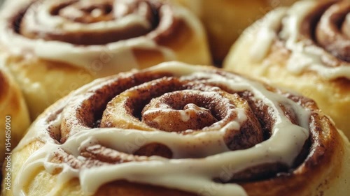 A close-up shot of sweet and fluffy cinnamon rolls covered in creamy icing