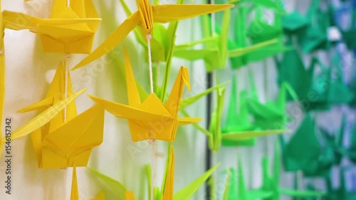 Artful display of colorful origami cranes on strings.