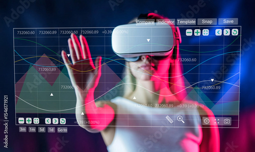 Woman in Virtual Reality Headset Interacting with Financial Data and Graphs in a Dimly Lit Environment for Technology and Innovation Themes