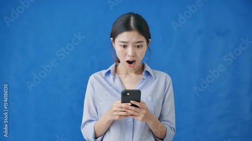 Asian businesswoman looking at phone shocked very surprised studio background video motion