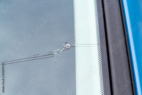 飛び石でヒビが入った車のフロントガラスの写真