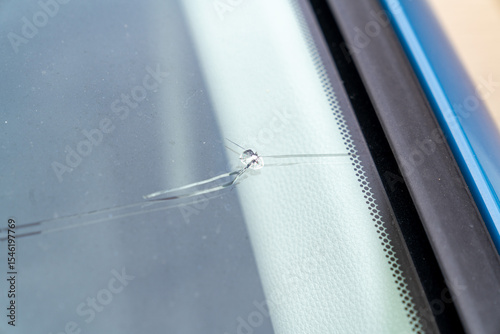 飛び石でヒビが入った車のフロントガラスの写真