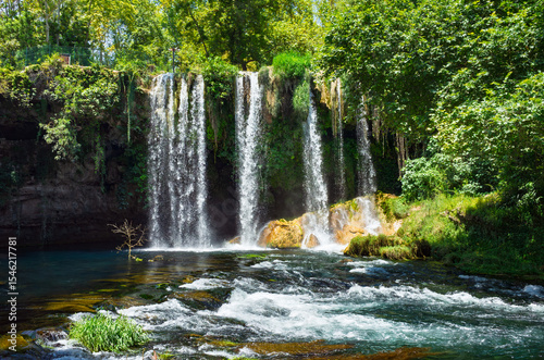 Antalya, Turkey: Upper Duden Waterfall cascade into river, surrounded by vibrant green trees. This famous Antalya waterfall is a peaceful and scenic natural attraction