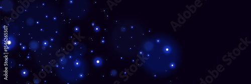 Blue glowing particles on dark background with soft bokeh light effect and dreamy cosmic atmosphere