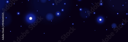 Blue glowing particles on dark background with soft bokeh light effect and dreamy cosmic atmosphere