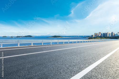 Empty asphalt coastal road with city skyline with blue sea in Zhuhai, China.