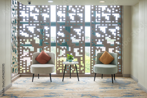An elegant seating area displays modern design infused with Asian influence via lattice screens, reminiscent of traditional Chinese window patterns photo