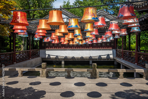 Ornate lanterns hang from a pavilion roof over a canal at Guyi Garden in Nanxiang, Shanghai, China. These lanterns reflect the artistry of traditional Chinese craftsmanship