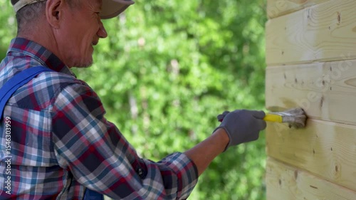 Man Painting Wooden House Wall Outdoors