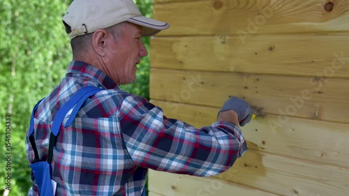 Man Painting Wooden House Wall Outdoors