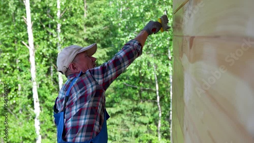 Man Painting Wooden House Wall Outdoors