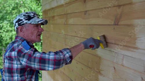 Man Painting Wooden House Wall Outdoors