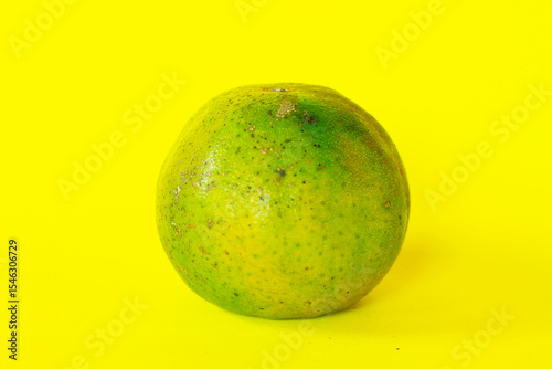 Fresh Green Orange on Bright Yellow Background is perfect for food marketing, tropical themes, health content, or naturally produced visuals.