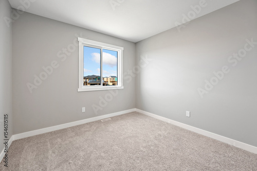 Very clean and empty bedroom with a large window