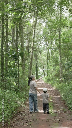 Asian mother and child exploring the forest together. A heartwarming journey through nature filled with curiosity, learning, and emotional bonding in peaceful surroundings.
