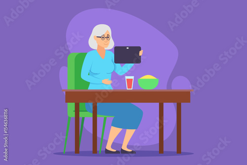 Elderly woman sitting comfortably at wooden table, using tablet while enjoying snack of fruit in bowl and drink