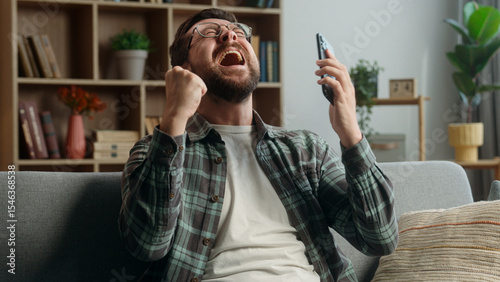 Foto Cheerful rejoice happy winner champion yelling happiness man at home guy male ga